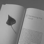 Open book with a leaf bookmark, showing the text 'Renewing the Mind'.